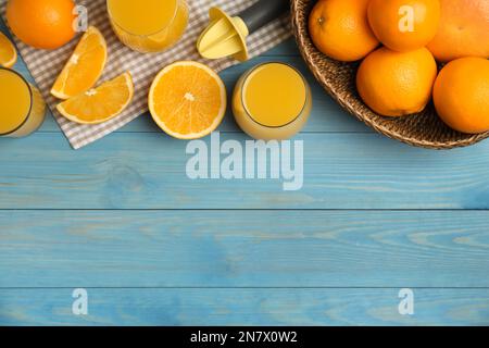 Frisch zubereiteter Saft, Orangen und Reibahle auf blauem Holztisch, flach liegend. Platz für Text Stockfoto