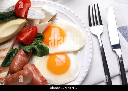 Köstliches Frühstück mit Spiegeleiern, serviert auf dem Tisch, Nahaufnahme Stockfoto