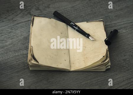 Tintenstift hat altes Notebook geöffnet Stockfoto