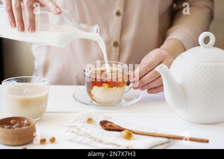 Person, die den Milchtee zubereitet, in der Vorderansicht Stockfoto