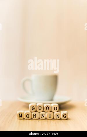 Schließen Sie die „Good Morning“-Würfelblöcke mit einer Tasse Kaffee aus Holz Stockfoto