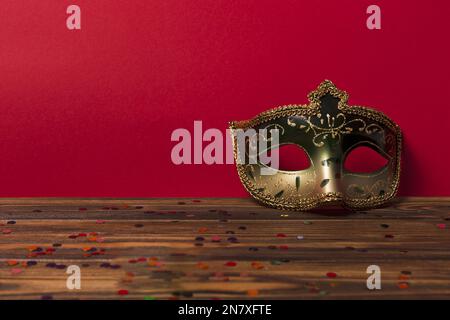 karneval Maske in der Nähe der roten Wand Stockfoto