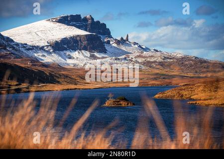 Isle of Skye, Schottland - das wunderschöne Loch Fada (See Fada) und die schneebedeckten Gipfel des Old man of Storr an einem sonnigen Frühlingsmorgen mit blauem Himmel und Wolken Stockfoto