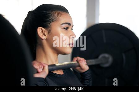 Bleiben Sie fit. Eine junge Frau, die mit einer Hacke im Fitnessstudio trainiert. Stockfoto