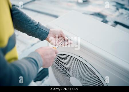 Hände, Klimaanlage und Wartung mit einem Bauarbeiter auf dem Dach, um ein Kühlsystem zu installieren. Ingenieur-, hlk- und Klimaanlagenreparatur mit einem Stockfoto