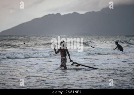 Ein Surfer bei Sonnenuntergang in Cenang Beach, Langkawi, Malaysia. Stockfoto