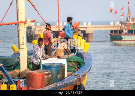 Diu, Indien - Dezember 2018: Fischer, die auf einem farbenfrohen Fischerboot vor der Küste der Insel Diu unterwegs sind. Stockfoto