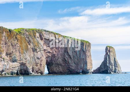 Blick auf den Percé Rock, eine riesige steile Felsformation im Golf von St. Lawrence an der Spitze der Gaspé-Halbinsel in Québec, Kanada, vor der Percé Bay. Stockfoto