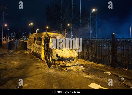 Ein ausgebrannter Polizeiwagen nach einer Demonstration vor dem Suites Hotel in Knowsley, Merseyside, wo Leute gegen Asylbewerber protestierten, die im Hotel wohnten. Die Polizei von Merseyside sagte, dass Offiziere in Prescot mit zwei Gruppen von Demonstranten zu tun haben. Foto: Freitag, 10. Februar 2023. Stockfoto