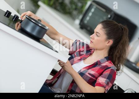 behinderte Frau, die in ihrer Küche kochen Stockfoto