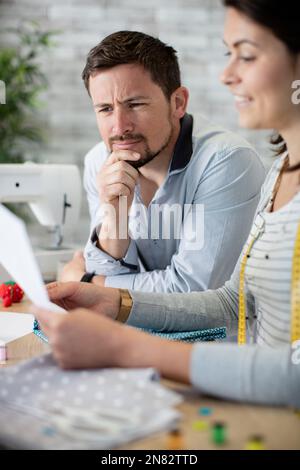 Männer und glückliche Frauen, die Modebekleidung kreieren Stockfoto