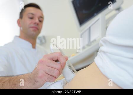 Mensch und Ultraschall am Bauch Stockfoto