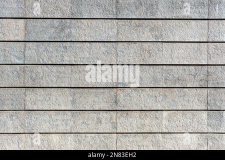 Hintergrund von einer Wand aus grauen Granitsteinen Stockfoto