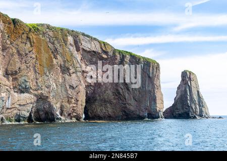 Blick auf den Percé Rock, eine riesige steile Felsformation im Golf von St. Lawrence an der Spitze der Gaspé-Halbinsel in Québec, Kanada, vor der Percé Bay. Stockfoto