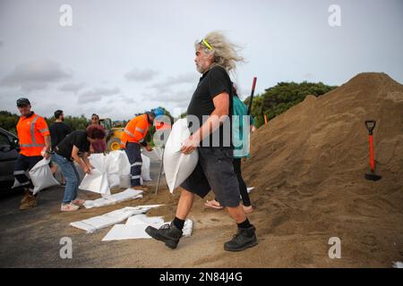 Aukland, Neuseeland. 11. Februar 2023. Ein Bewohner trägt einen Sandsack in einer temporären Sandlagerstätte in Auckland, Neuseeland, 11. Februar 2023. Neuseelands größte Stadt Auckland richtete temporäre Sandlagerstätten ein und stellte den Bewohnern Sandsäcke zur Verfügung, um sich auf neue Unwetterereignisse vorzubereiten. Die letzte Rekordregenrunde hat seit Januar 27 massive Überschwemmungen an Häusern und Grundstücken verursacht. Kredit: Zhao Gang/Xinhua/Alamy Live News Stockfoto