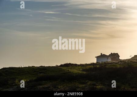 Zandvoort, Niederlande, 5. Februar 2023: Zwei Häuser auf einer Düne in der Abendsonne Stockfoto