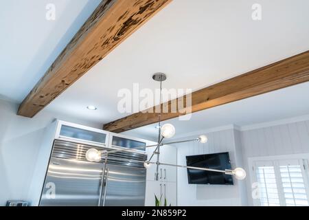 Holzbalken in einer weißen Küche eines frisch renovierten Hauses Stockfoto