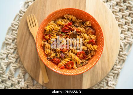 Von oben genießen Sie köstliche hausgemachte vegane Pasta, glutenfrei mit sonnengetrockneten Tomaten Stockfoto