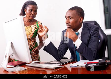 Porträt eines jungen Geschäftsmannes und seiner Sekretärin, die im Büro miteinander diskutieren. Stockfoto