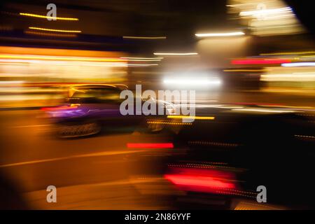Das Bild mit der Kamera machte Bewegungsunschärfe abstrakter Lichtstrecken vom Nachtverkehr Stockfoto