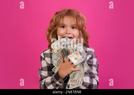 Der Junge hat viele hundert Dollar isoliert auf rosa rotem Hintergrund. Stockfoto