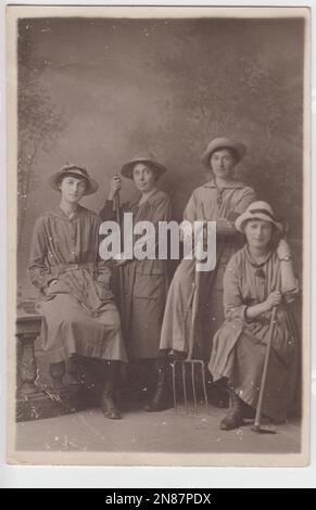 Frauen-Landarmee im Ersten Weltkrieg: Porträt von vier Frauen in Arbeitskleidung, drei von ihnen halten landwirtschaftliche Werkzeuge, darunter eine Gabel und eine Hacke. Das Foto wurde von West Bromwich Fotograf Horace Dudley aufgenommen Stockfoto