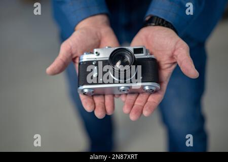 Männerhände halten eine alte Kamera Stockfoto