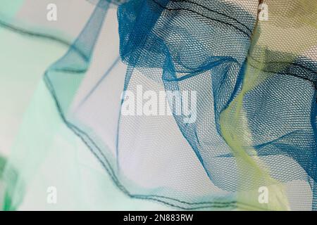 Duftende und zarte Tüll leuchten grün, blau und gelb auf weißem Hintergrund. Stockfoto