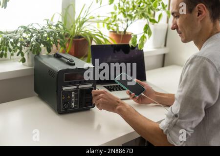 Ein Mann verwendet eine tragbare Ladestation Stockfoto