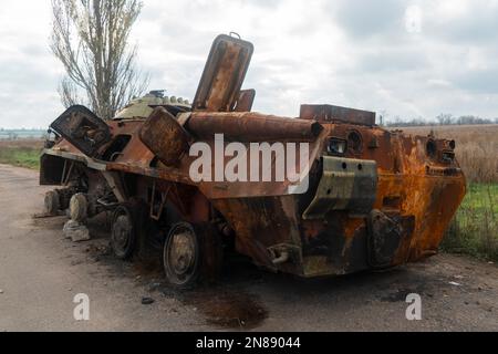 Auf Dem Land. Nach der Schlacht. Zerstörtes verbranntes Kampffahrzeug steht am Straßenrand. Krieg in der Ukraine. Russische Invasion der Ukraine Stockfoto