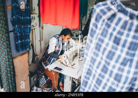 Manali, Himachal Pradesh, Indien - 27. August 2016: Yuong-man-Kanalisation, die auf der Straße mit einer Nähmaschine in der Siedlung Manali, Himachal Pradesh, arbeitet Stockfoto