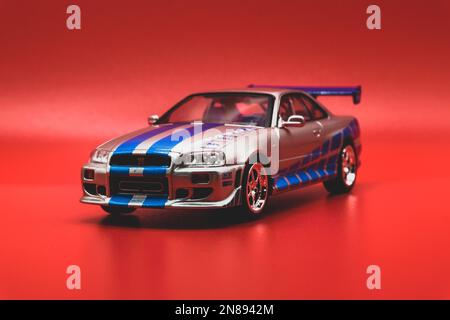 Fast&Furious Nissan Skyline GT-R R34 1:43, Vorderansicht, roter Hintergrund Stockfoto