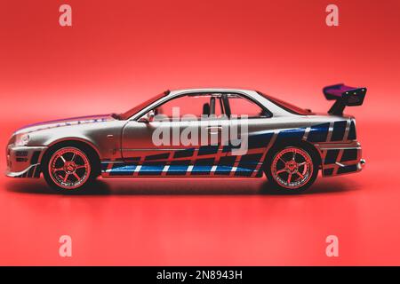 Fast&Furious Nissan Skyline GT-R R34 1:43, Seitenansicht, roter Hintergrund Stockfoto