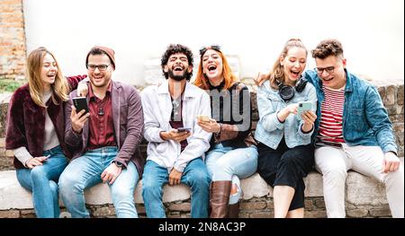 Junge Stadtmenschen, die ihr Smartphone auf dem Hof der Universität benutzen - Milenial genz-Freunde, die von ihrem Smartphone abhängig sind - Life Style Tech-Konzept Stockfoto