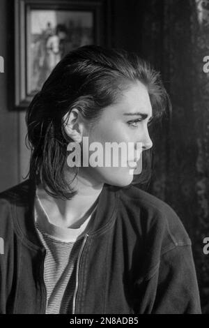 Ehrliches Porträt einer jungen Frau, die wehmütig aus einem Kneipenfenster 1990er southsea england uk guckt Stockfoto