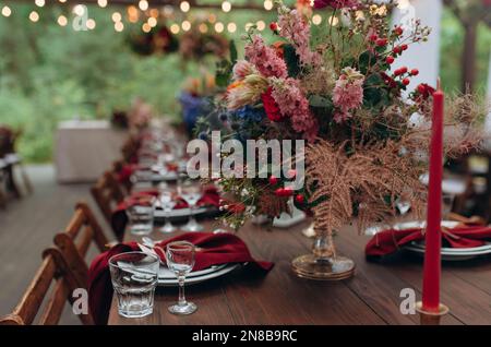 Schöne Blumen auf dem Tisch. Tische für eine Eventparty oder einen Hochzeitsempfang gedeckt. Stockfoto