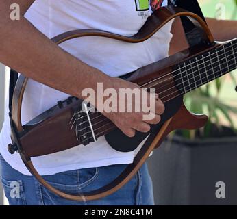 Ein Mann (El Tiko Frometa) spielt draußen eine elektrische, offene, gerahmte Rock-Gitarre mit 6 Saiten Stockfoto