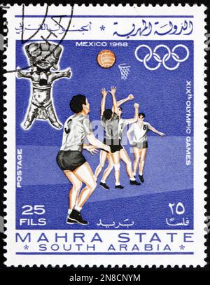 BUNDESSTAAT MAHRA - CA. 1967: Ein in Mahra Sultanate gedruckter Stempel zeigt Basketball, Olympische Sommerspiele 1968, Mexiko-Stadt, ca. 1967 Stockfoto