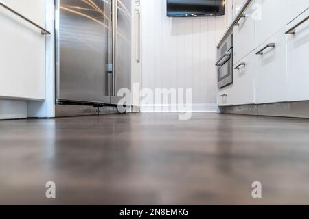 Dunkle Holzböden in einem frisch renovierten weißen Schrank, moderne Küche Stockfoto