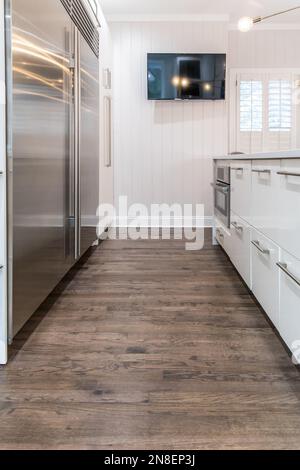 Dunkle Holzböden in einem frisch renovierten weißen Schrank, moderne Küche. Stockfoto