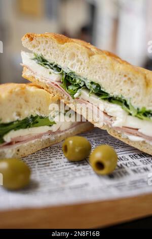 Zwei leckere und appetitliche Sandwiches mit Käse, Würstchen und Salatblättern Stockfoto