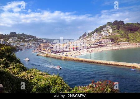 Ein erhöhter Blick auf Boote auf dem Fluss Looe mit Urlaubern, die Sommerwetter am Strand von East Looe, Looe, Cornwall, England, Großbritannien genießen Stockfoto