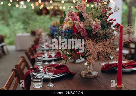Schöne Blumen auf dem Tisch. Tische für eine Eventparty oder einen Hochzeitsempfang gedeckt. Stockfoto