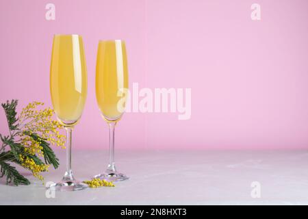 Gläser Mimosa-Cocktail auf einem hellen Tisch. Platz für Text Stockfoto