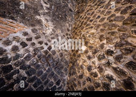 Nahaufnahme der antiken römischen Steinmauer in den Ruinen von Pompeji, Italien Stockfoto