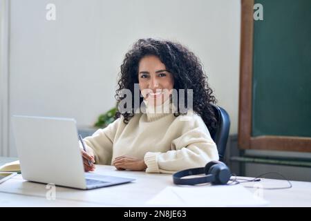 Junge lächelnde Geschäftsfrau am Schreibtisch mit Laptop. Porträt Stockfoto