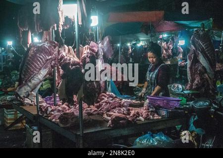 Eine kambodschanische Metzgerin schneidet nachts rohes Fleisch auf dem wichtigsten Gemüse- und Fleischgroßmarkt. Phsar Dumkor, Phnom Penh, Kambodscha. © Kraig Stockfoto