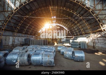 Rollen aus verzinktem Stahldraht, Armaturen und Drahtgitter im Lagergebäude. Stockfoto