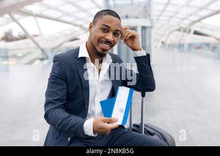 Porträt Eines Gutaussehenden Schwarzen Geschäftsmanns Mit Reisepass Und Flugtickets In Der Hand Stockfoto