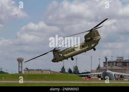 Ein Boeing CH 47 Chinook Helikopter mit der US-Armee vor einem USAF C17 Globemaster-Frachtflugzeug am Yokota Airbase, Fussa, Tokio, Japan. Stockfoto